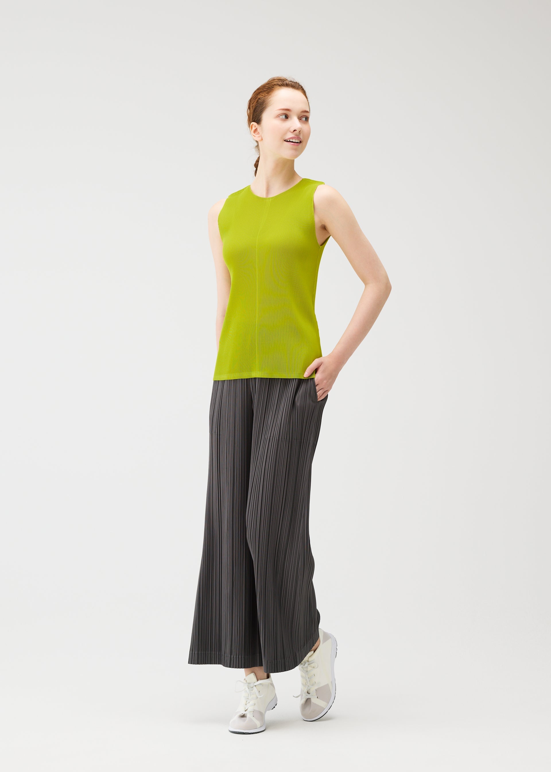 A model wears the PLEATS PLEASE ISSEY MIYAKE OPAQUE BOTTOMS opaque-bottoms-trousers-off-white.