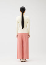 A model wears the PLEATS PLEASE ISSEY MIYAKE RAMIE PLEATS trousers.