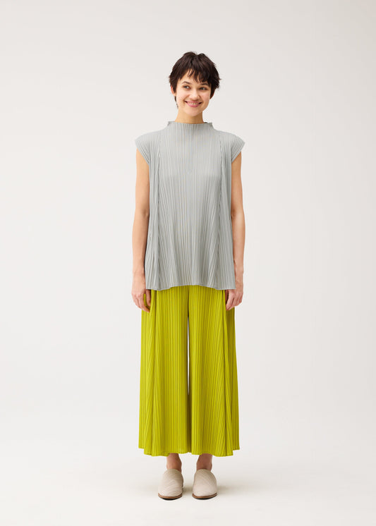 A model wears the PLEATS PLEASE ISSEY MIYAKE MELLOW PLEATS trousers.