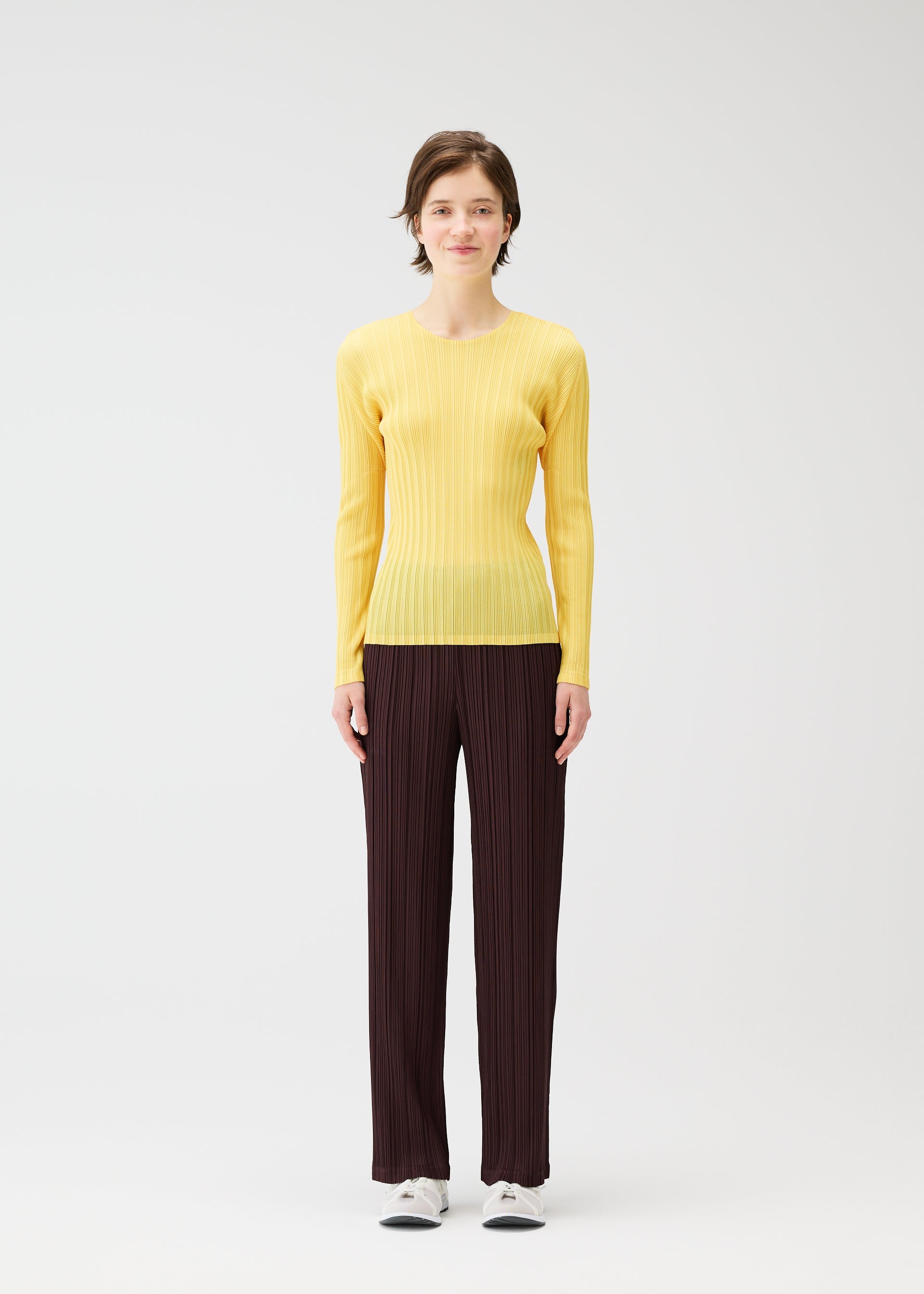 A model wears the PLEATS PLEASE ISSEY MIYAKE THICKER BOTTOMS 1 clothing.