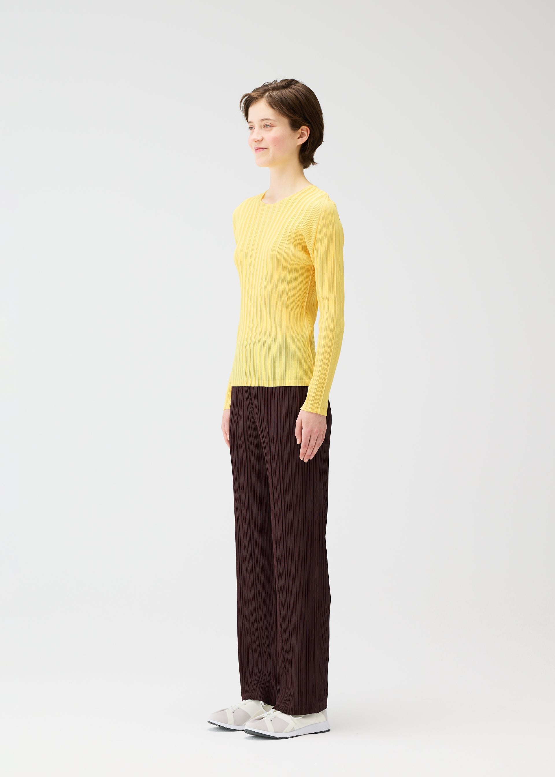 A model wears the PLEATS PLEASE ISSEY MIYAKE THICKER BOTTOMS 1 clothing.