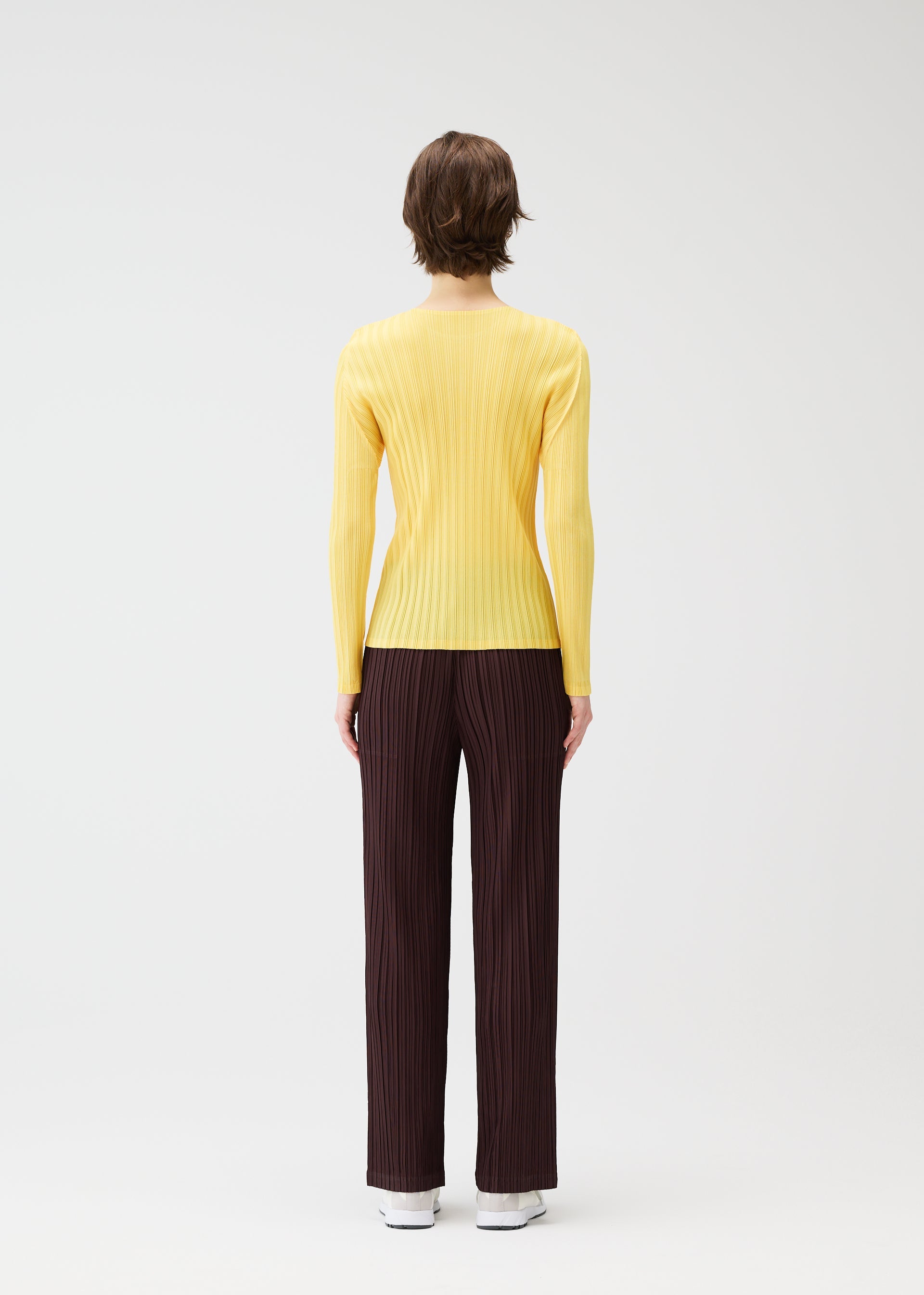 A model wears the PLEATS PLEASE ISSEY MIYAKE THICKER BOTTOMS 1 clothing.