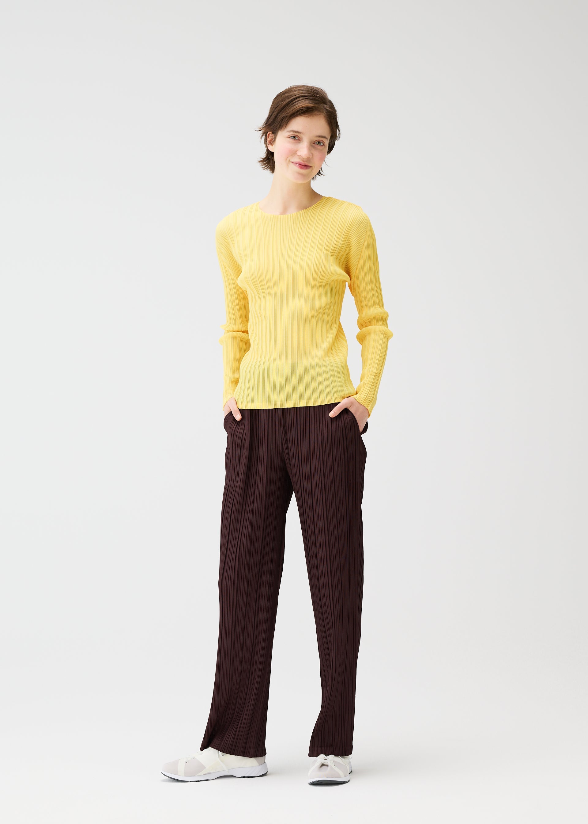 A model wears the PLEATS PLEASE ISSEY MIYAKE THICKER BOTTOMS 1 clothing.