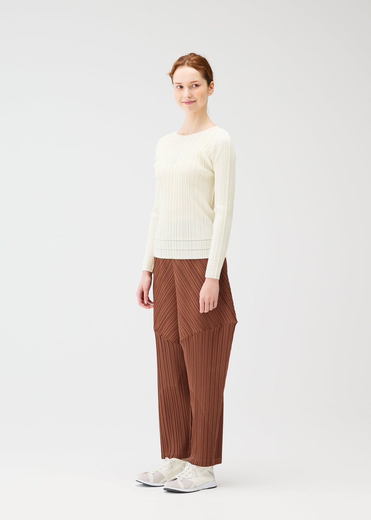 A model wears the PLEATS PLEASE ISSEY MIYAKE THICKER BOTTOMS 2 trousers.