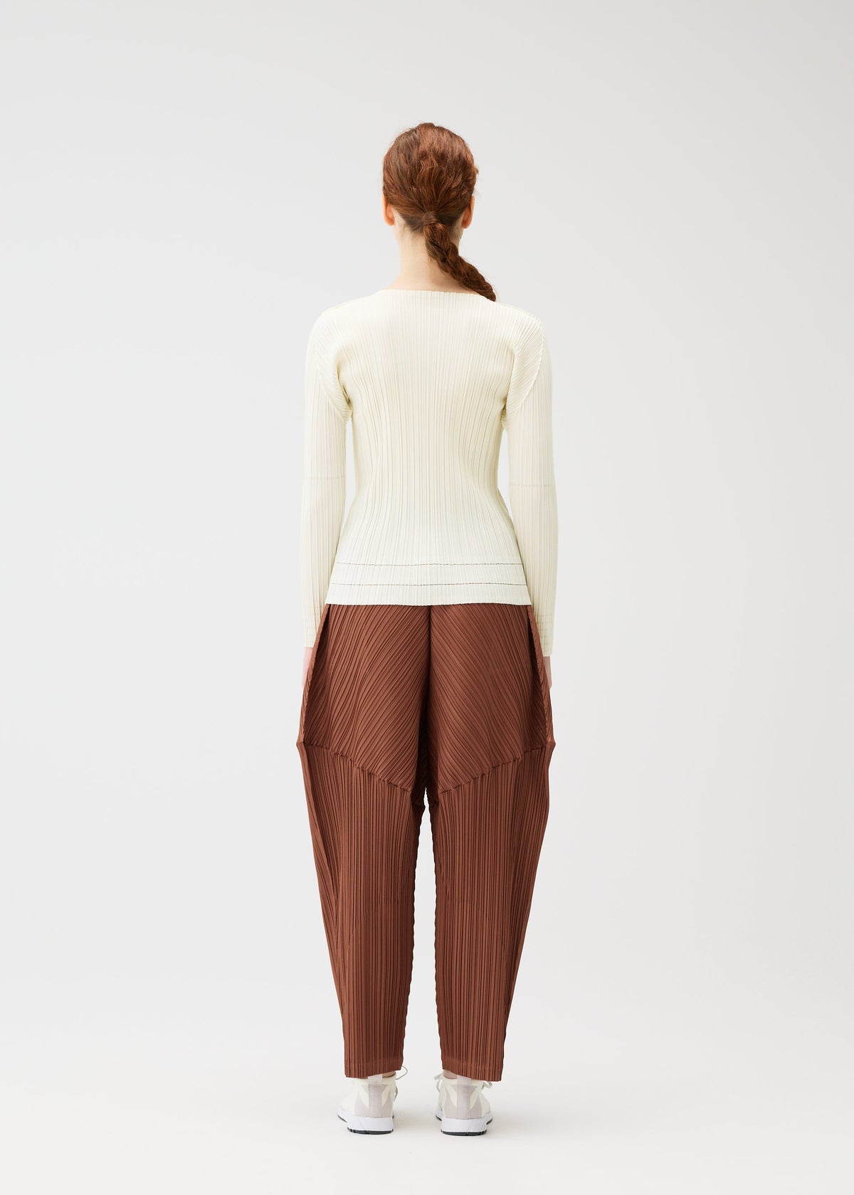 A model wears the PLEATS PLEASE ISSEY MIYAKE THICKER BOTTOMS 2 trousers.