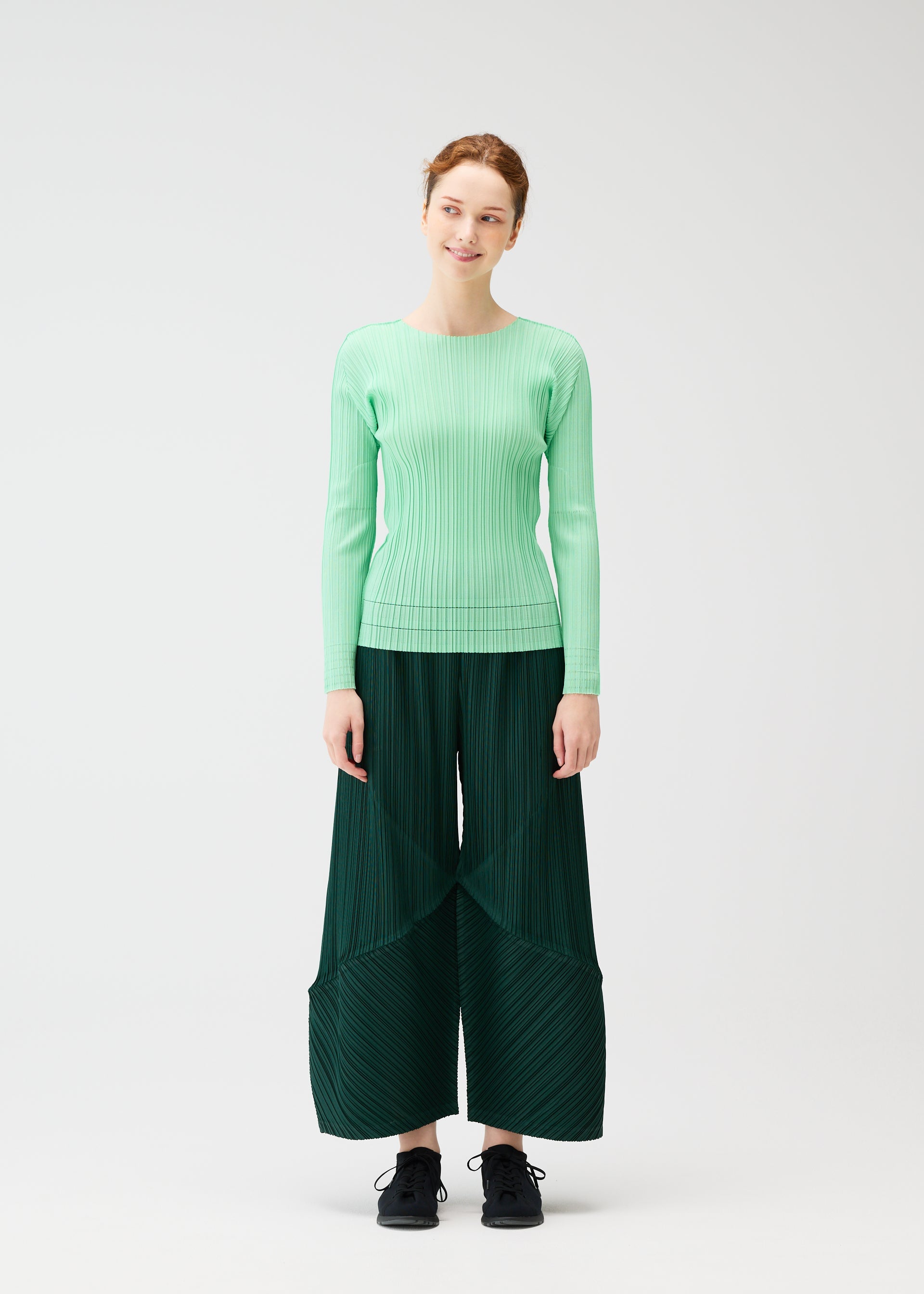 A model wears the PLEATS PLEASE ISSEY MIYAKE THICKER BOTTOMS 2 trousers.