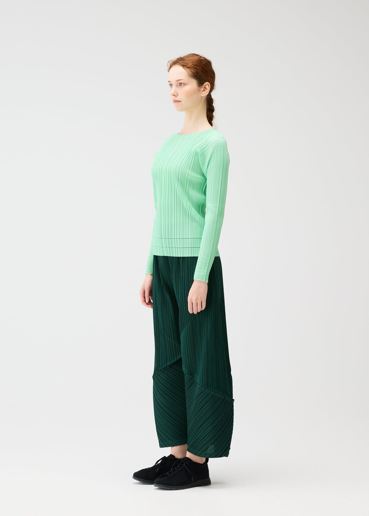 A model wears the PLEATS PLEASE ISSEY MIYAKE THICKER BOTTOMS 2 trousers.