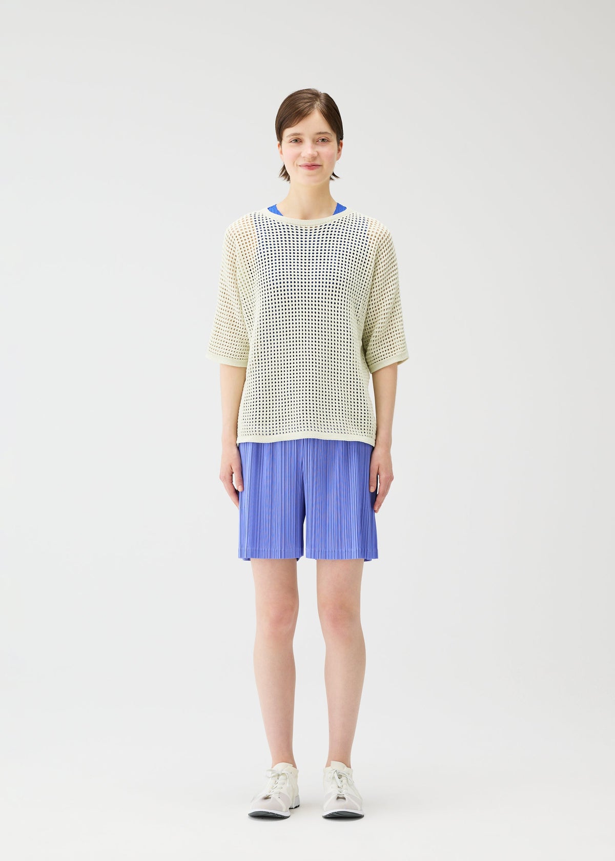 A model wears the PLEATS PLEASE ISSEY MIYAKE LOOP BOTTOMS shorts.