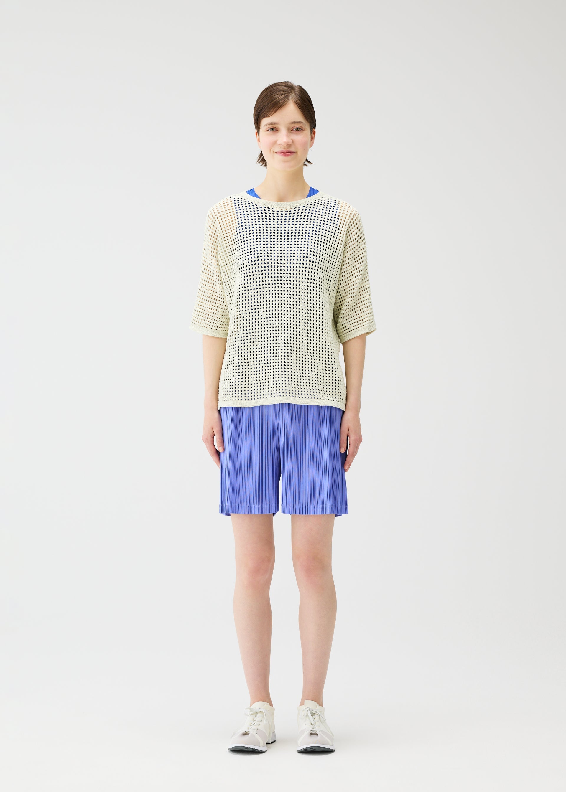 A model wears the PLEATS PLEASE ISSEY MIYAKE LOOP BOTTOMS shorts.