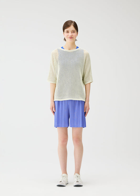 A model wears the PLEATS PLEASE ISSEY MIYAKE LOOP BOTTOMS shorts.