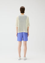A model wears the PLEATS PLEASE ISSEY MIYAKE LOOP BOTTOMS shorts.