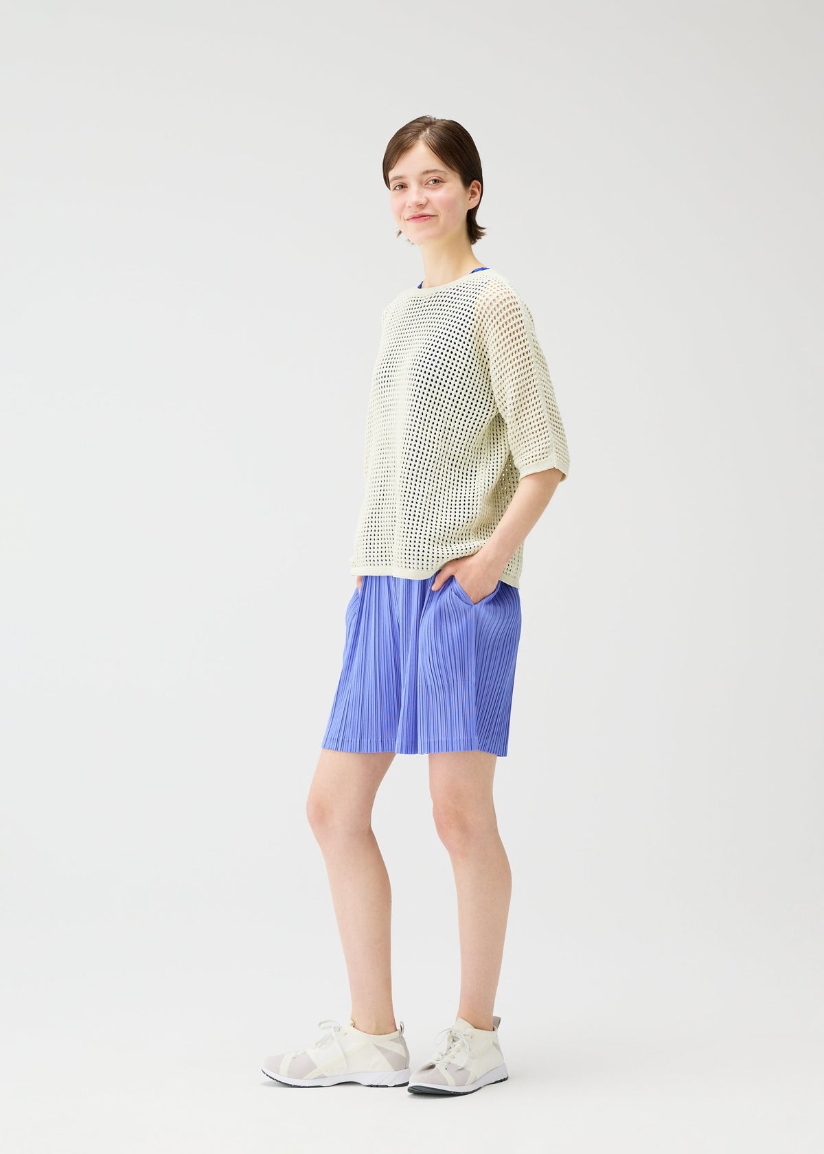 A model wears the PLEATS PLEASE ISSEY MIYAKE LOOP BOTTOMS shorts.