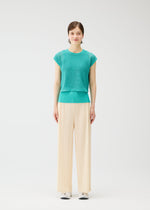 A model wears the PLEATS PLEASE ISSEY MIYAKE LOOP BOTTOMS trousers.