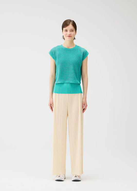 A model wears the PLEATS PLEASE ISSEY MIYAKE LOOP BOTTOMS trousers.