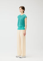 A model wears the PLEATS PLEASE ISSEY MIYAKE LOOP BOTTOMS trousers.