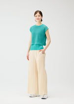 A model wears the PLEATS PLEASE ISSEY MIYAKE LOOP BOTTOMS trousers.