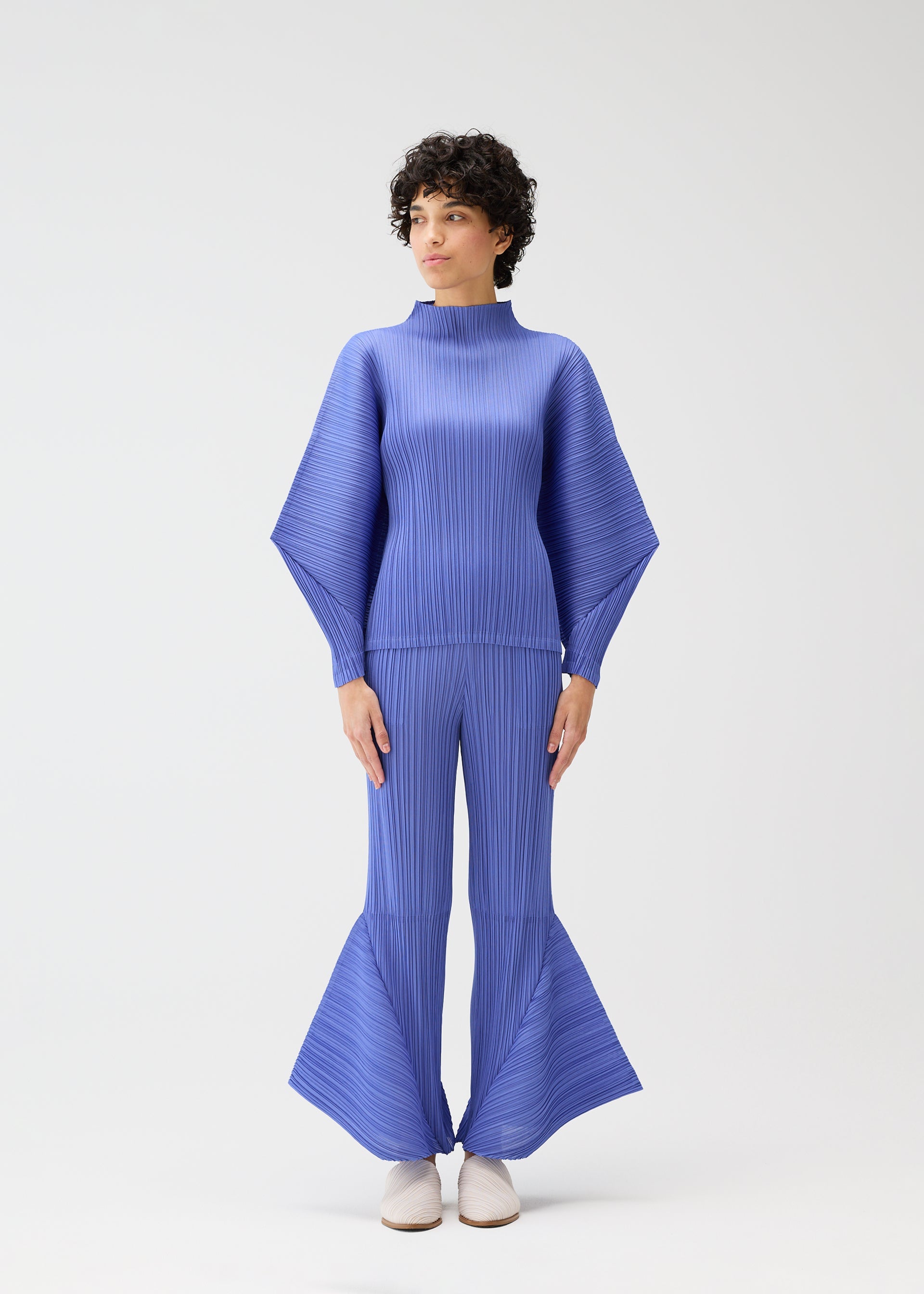 A model wears the PLEATS PLEASE ISSEY MIYAKE SKYLINE clothing.