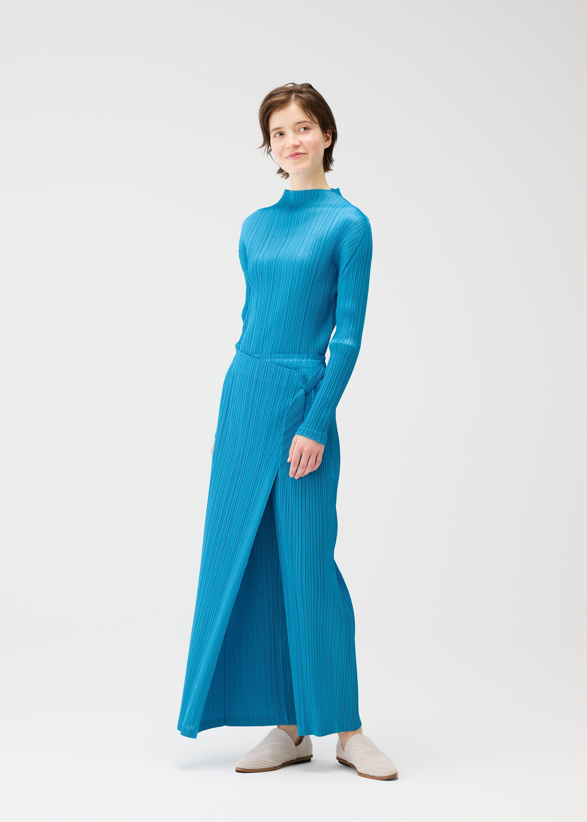 A model wears the PLEATS PLEASE ISSEY MIYAKE FACADE trousers.