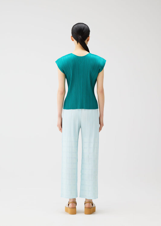 A model wears the PLEATS PLEASE ISSEY MIYAKE BUMPY BASKET bumpy-basket-trousers-green.