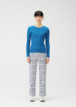 A model wears the PLEATS PLEASE ISSEY MIYAKE CROSSING DOTS trousers.