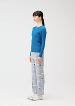 A model wears the PLEATS PLEASE ISSEY MIYAKE CROSSING DOTS trousers.
