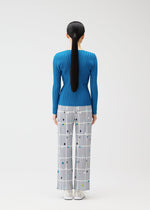 A model wears the PLEATS PLEASE ISSEY MIYAKE CROSSING DOTS trousers.