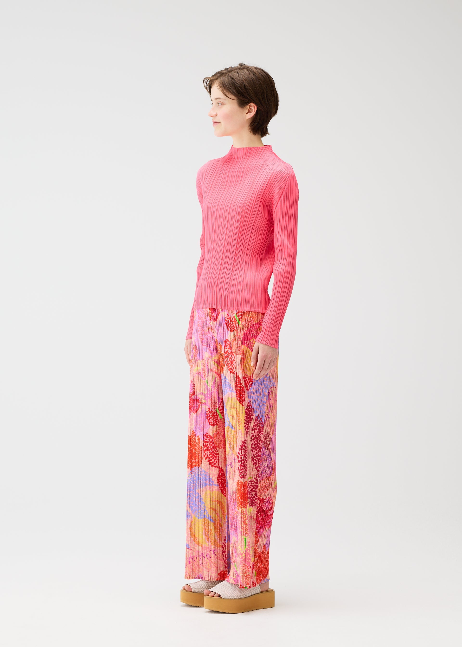 A model wears the PLEATS PLEASE ISSEY MIYAKE FOGGY FOREST trousers.
