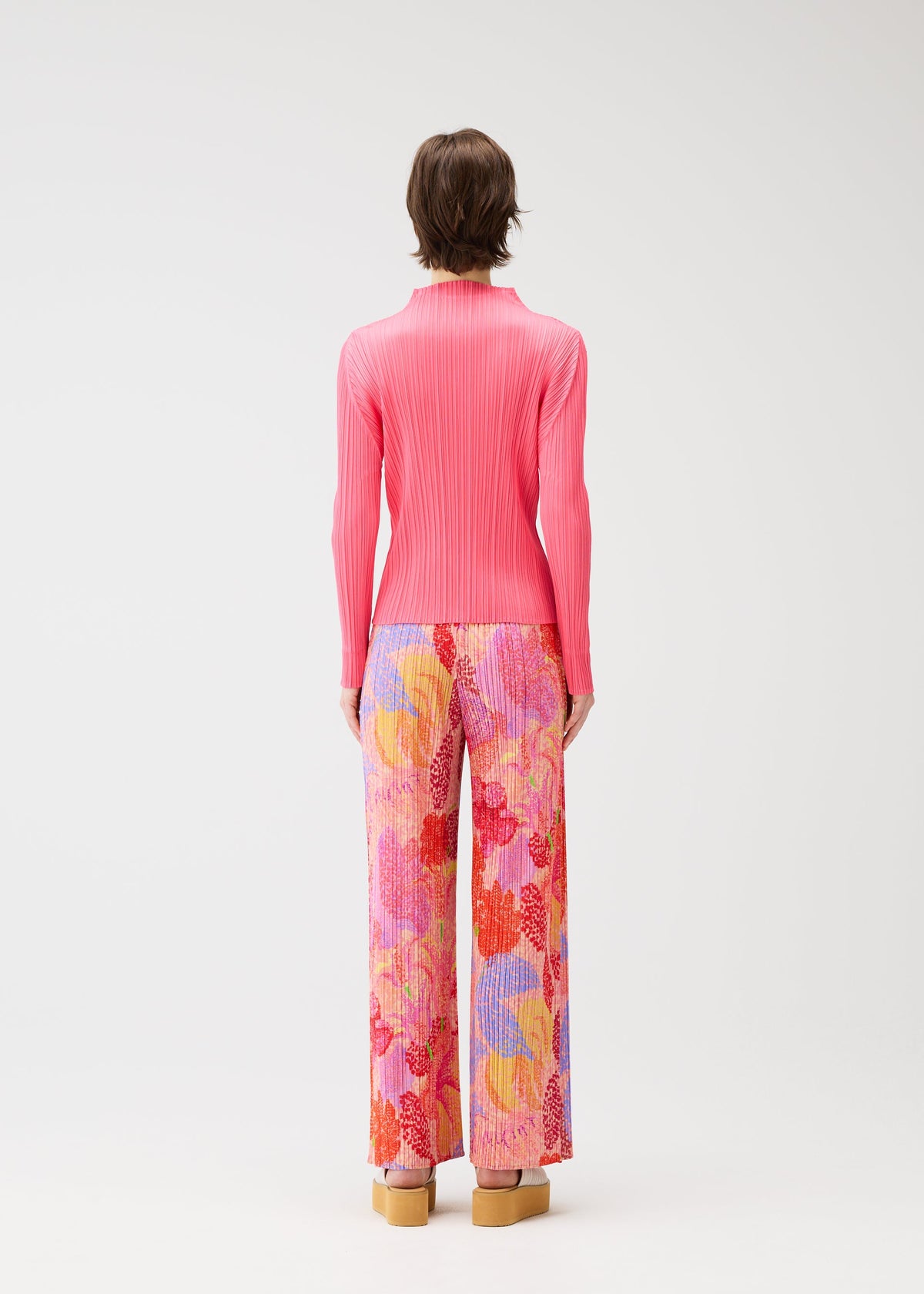 A model wears the PLEATS PLEASE ISSEY MIYAKE FOGGY FOREST trousers.