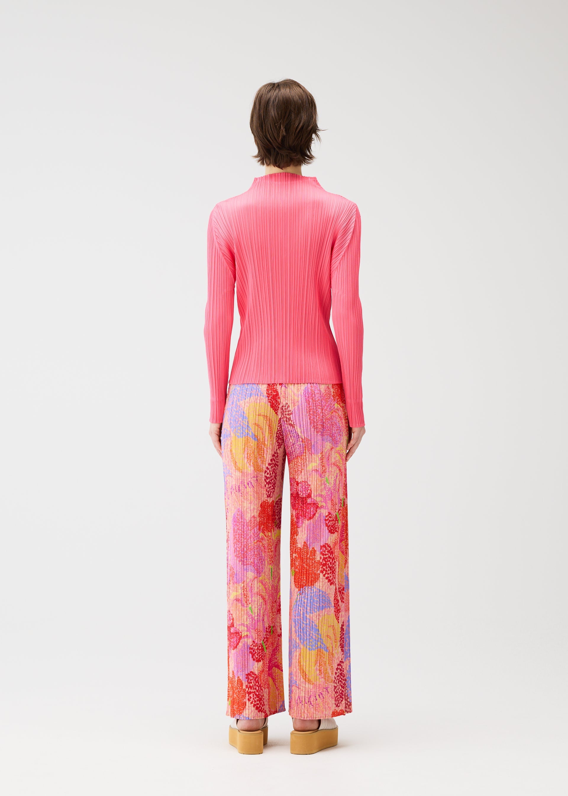 A model wears the PLEATS PLEASE ISSEY MIYAKE FOGGY FOREST trousers.