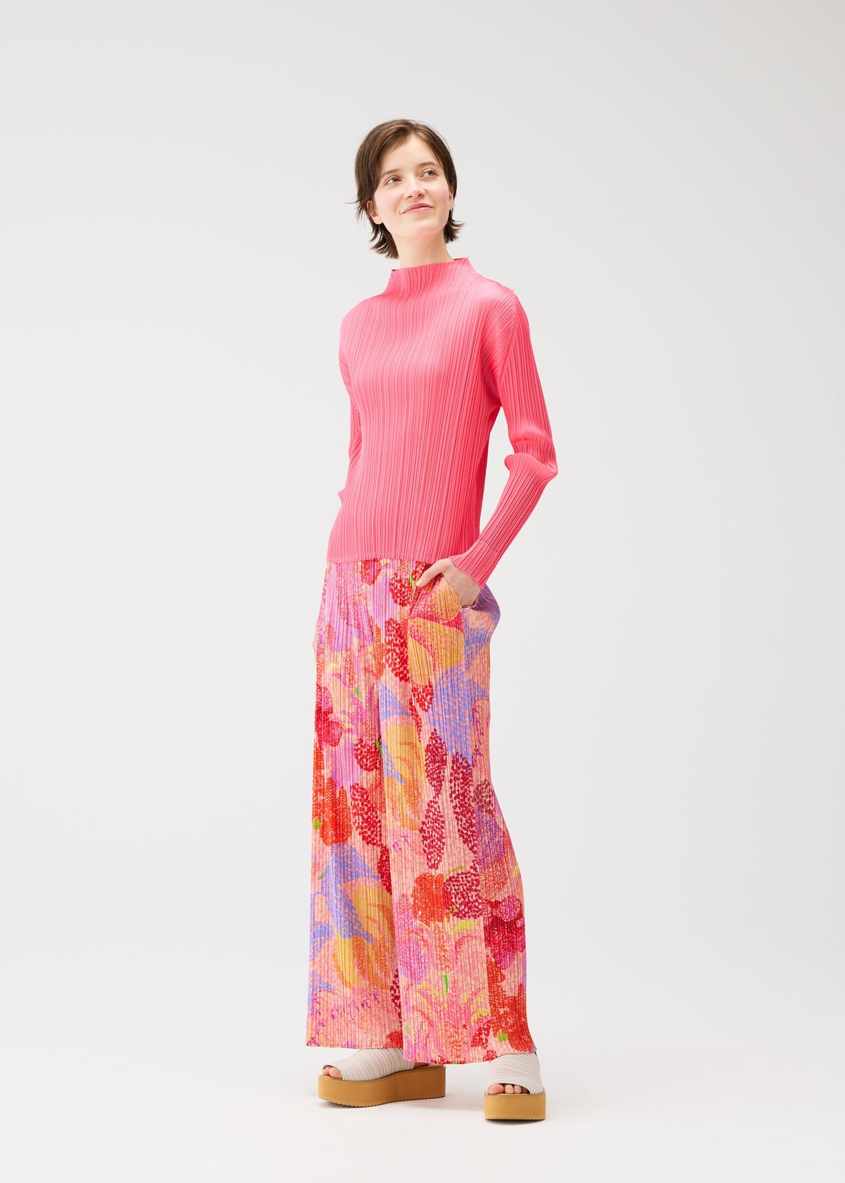 A model wears the PLEATS PLEASE ISSEY MIYAKE FOGGY FOREST trousers.