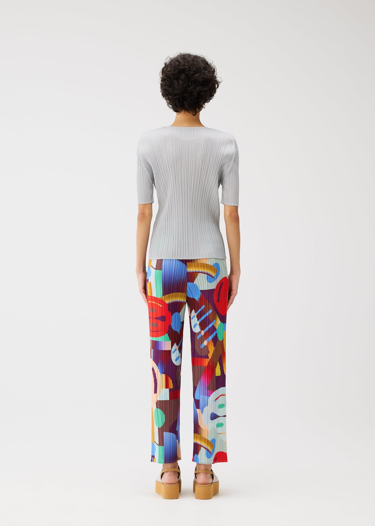A model wears the PLEATS PLEASE ISSEY MIYAKE PLAYGROUND trousers.