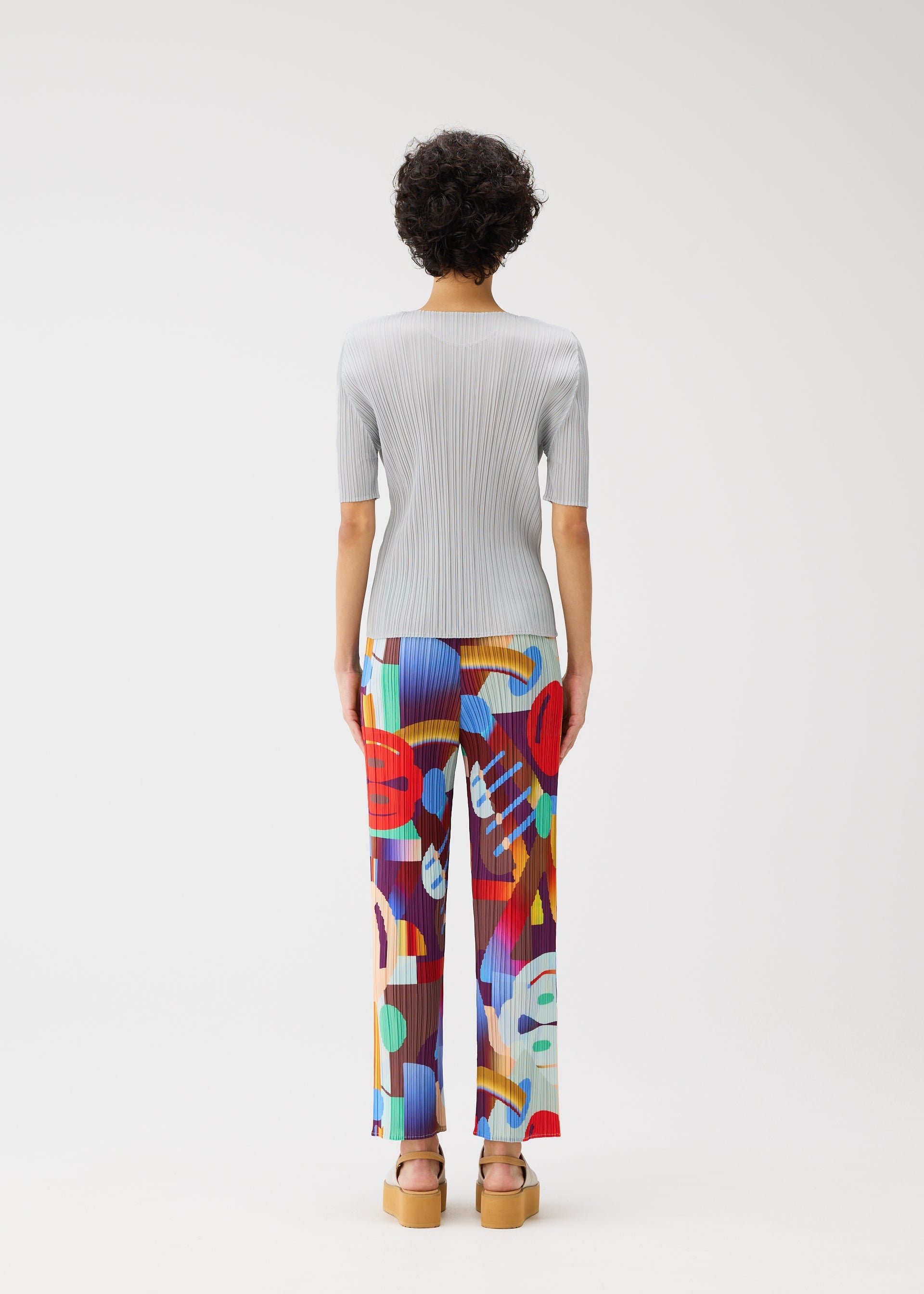 A model wears the PLEATS PLEASE ISSEY MIYAKE PLAYGROUND trousers.
