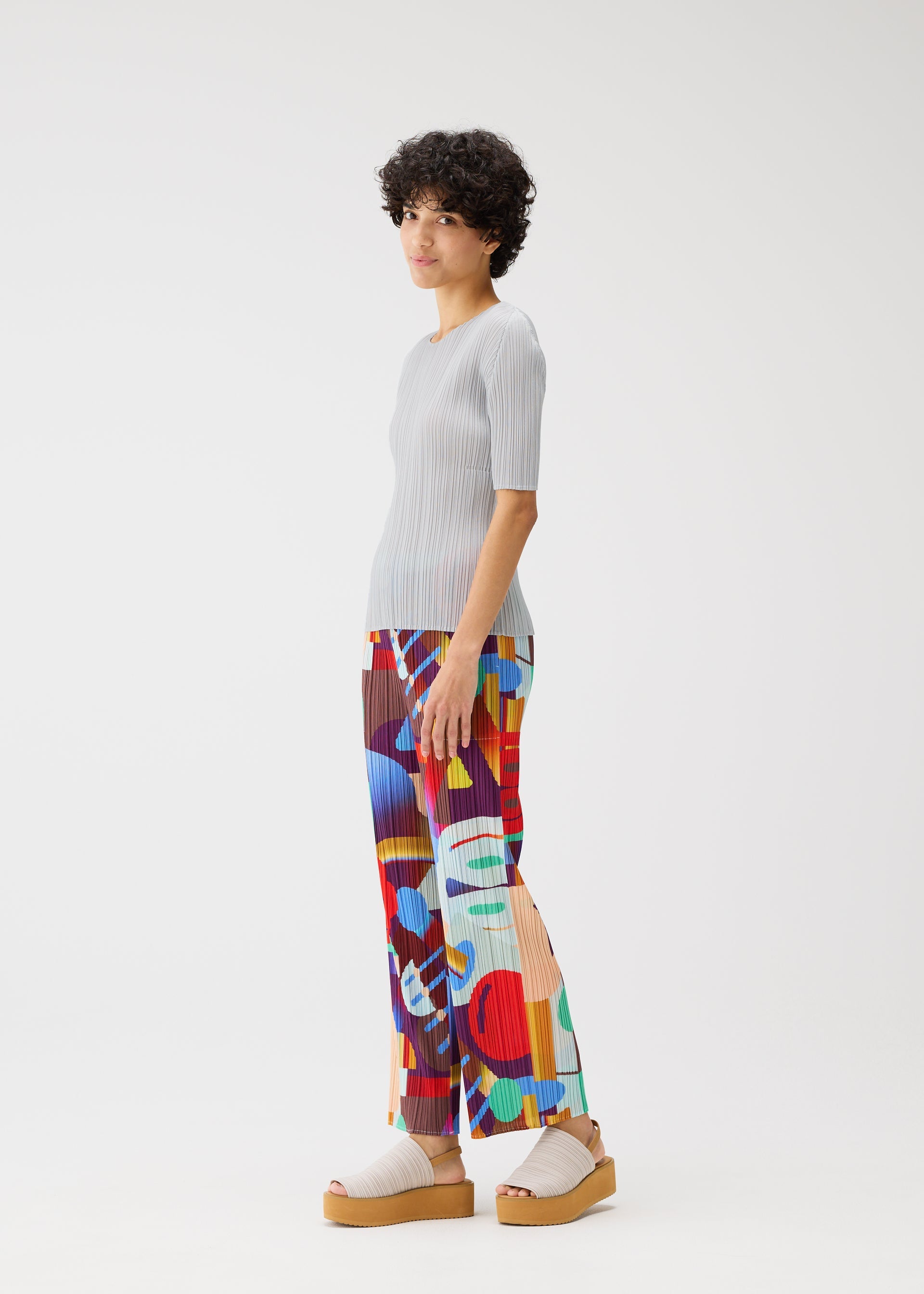 A model wears the PLEATS PLEASE ISSEY MIYAKE PLAYGROUND trousers.
