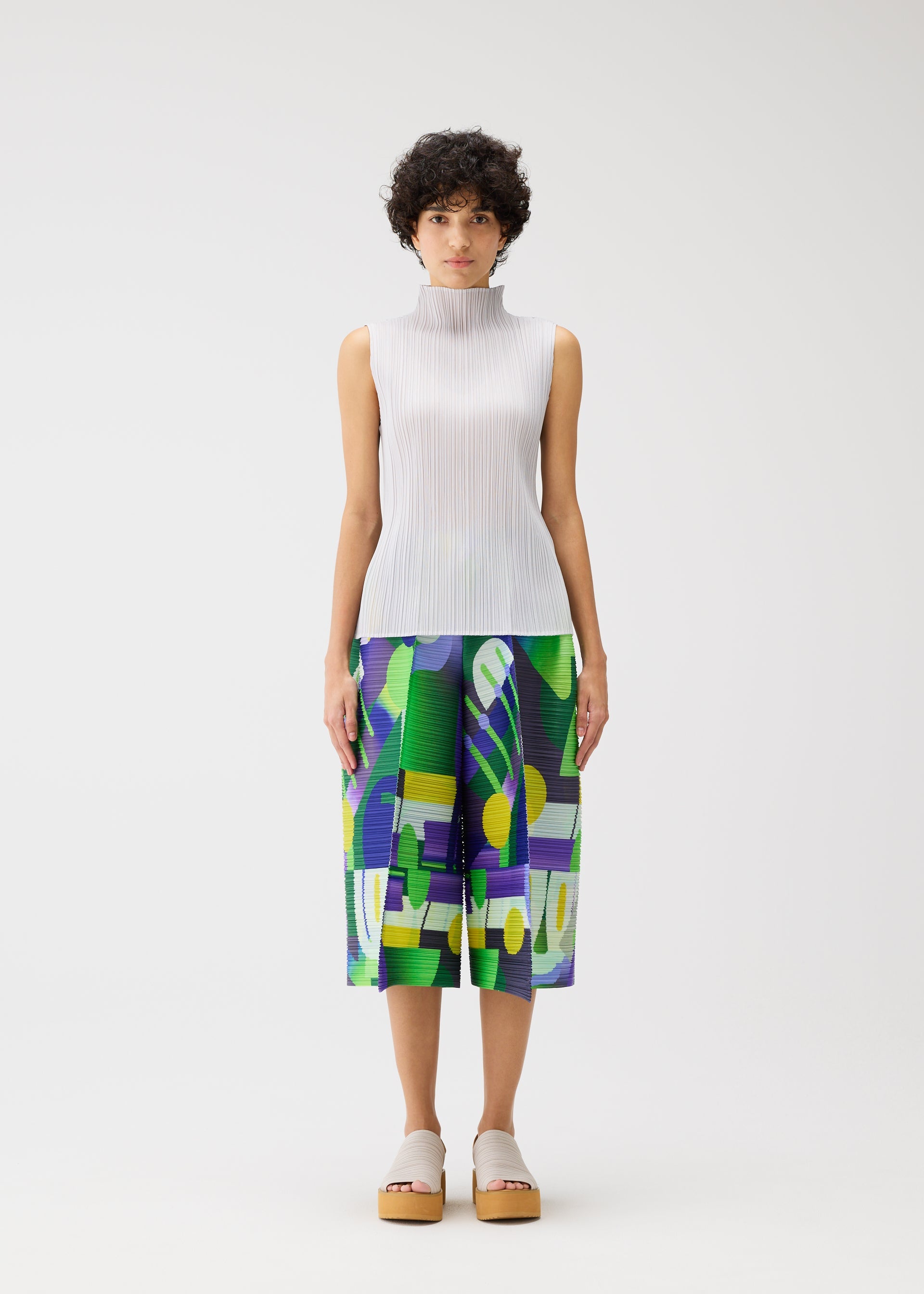 A model wears the PLEATS PLEASE ISSEY MIYAKE PLAYGROUND trousers.