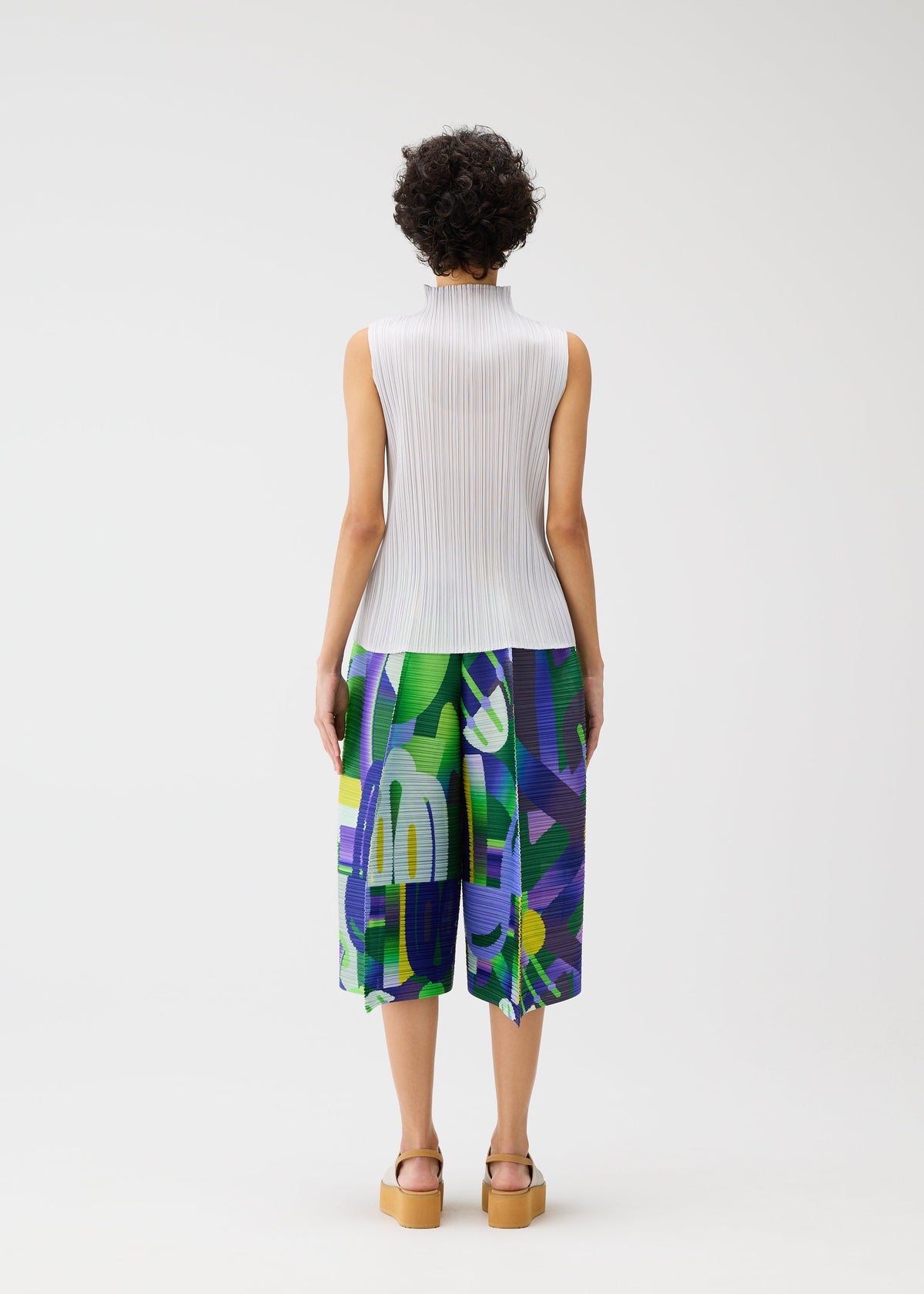 A model wears the PLEATS PLEASE ISSEY MIYAKE PLAYGROUND trousers.