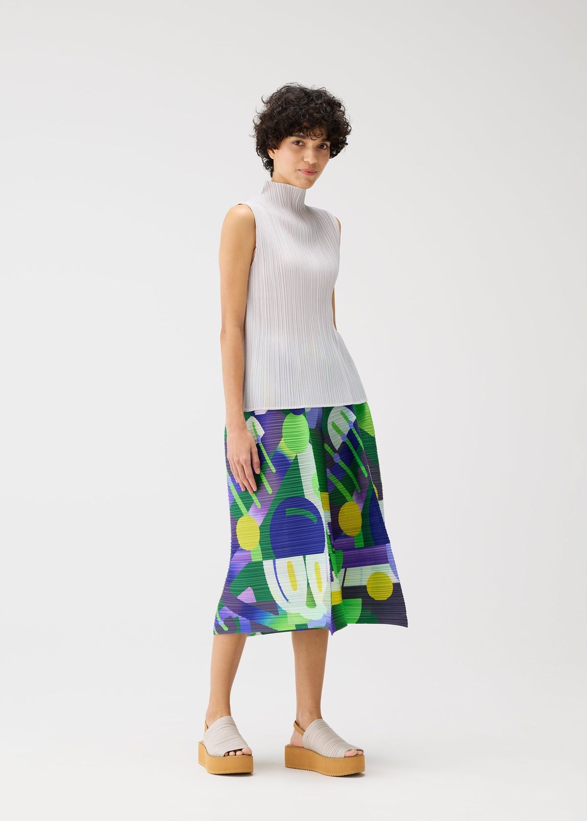 A model wears the PLEATS PLEASE ISSEY MIYAKE PLAYGROUND trousers.