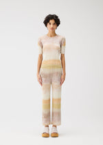 A model wears the PLEATS PLEASE ISSEY MIYAKE SEA BUBBLE trousers.