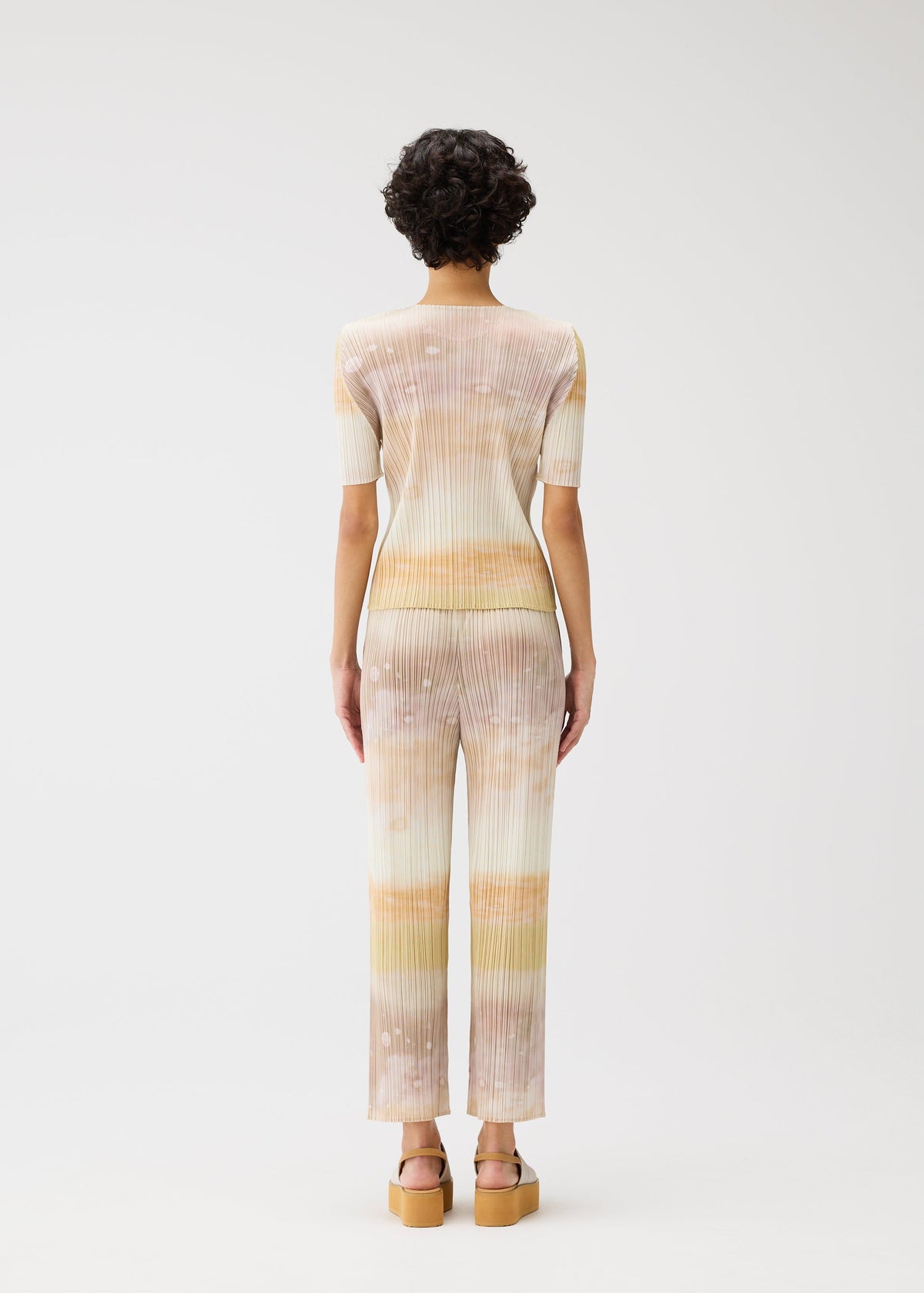 A model wears the PLEATS PLEASE ISSEY MIYAKE SEA BUBBLE trousers.