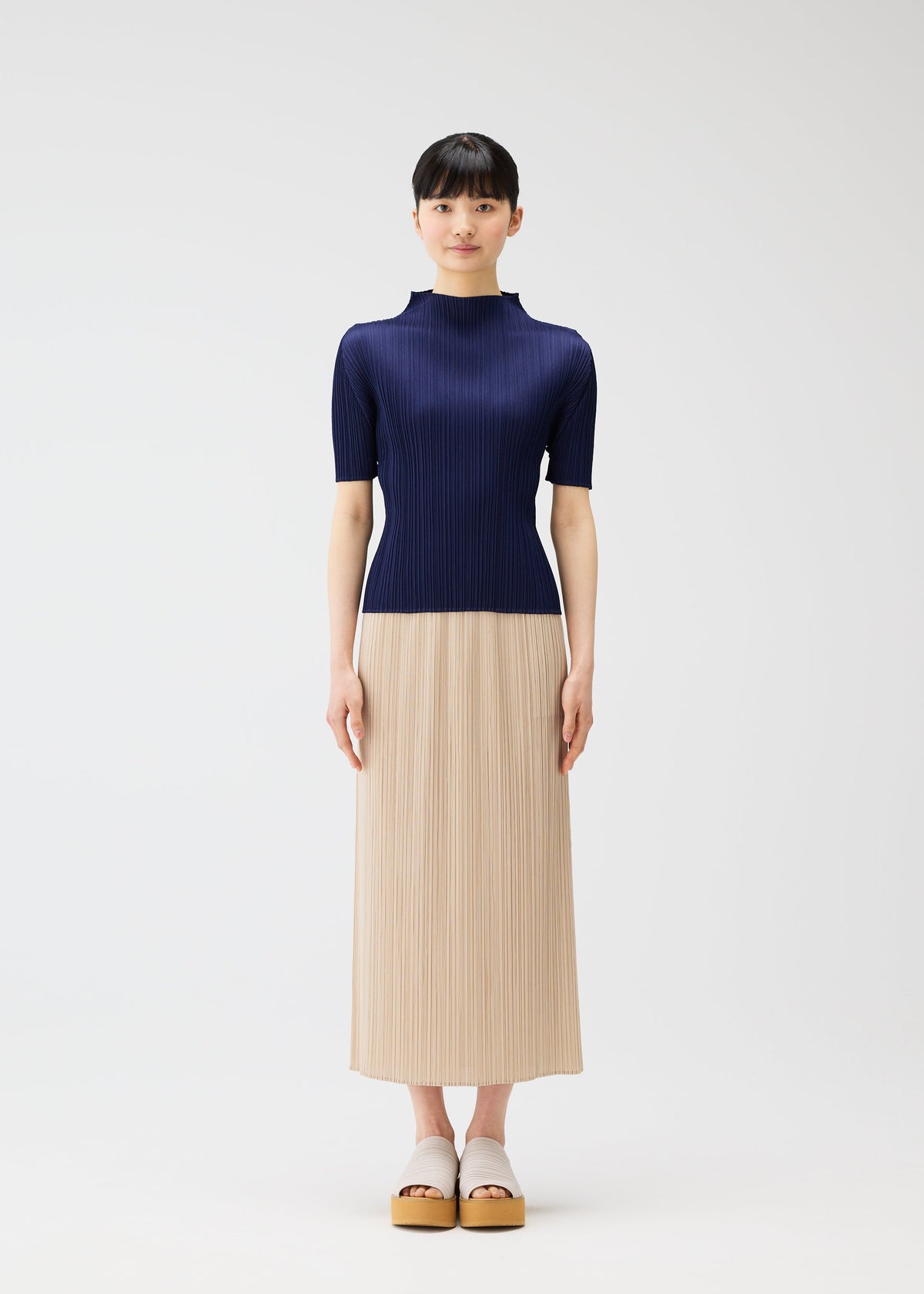 A model wears the PLEATS PLEASE ISSEY MIYAKE MONTHLY COLORS MAY skirt.