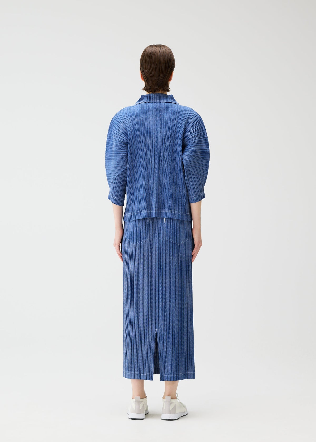 A model wears the PLEATS PLEASE ISSEY MIYAKE COTTON DENIM skirt.