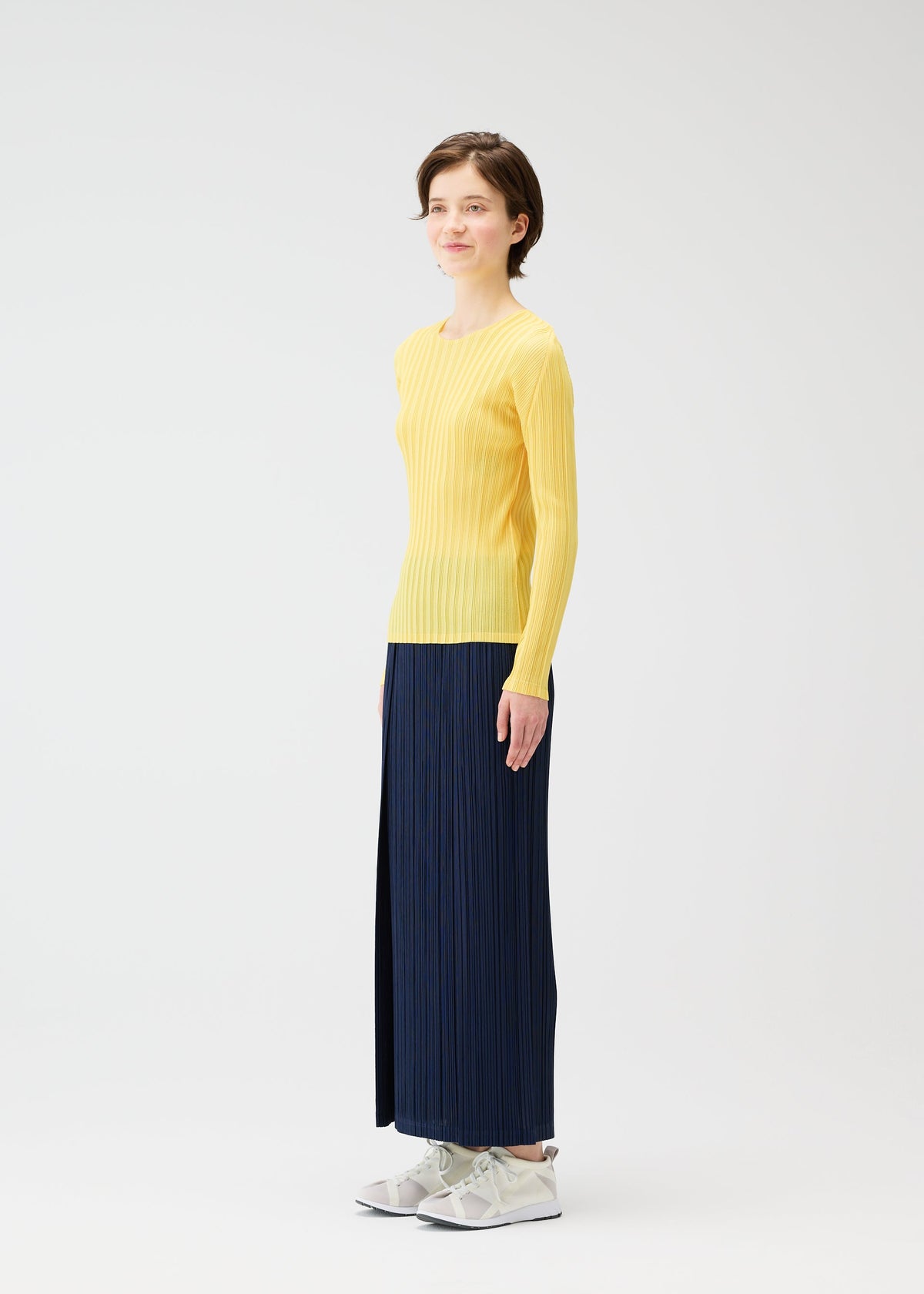 A model wears the PLEATS PLEASE ISSEY MIYAKE THICKER BOTTOMS 1 clothing.
