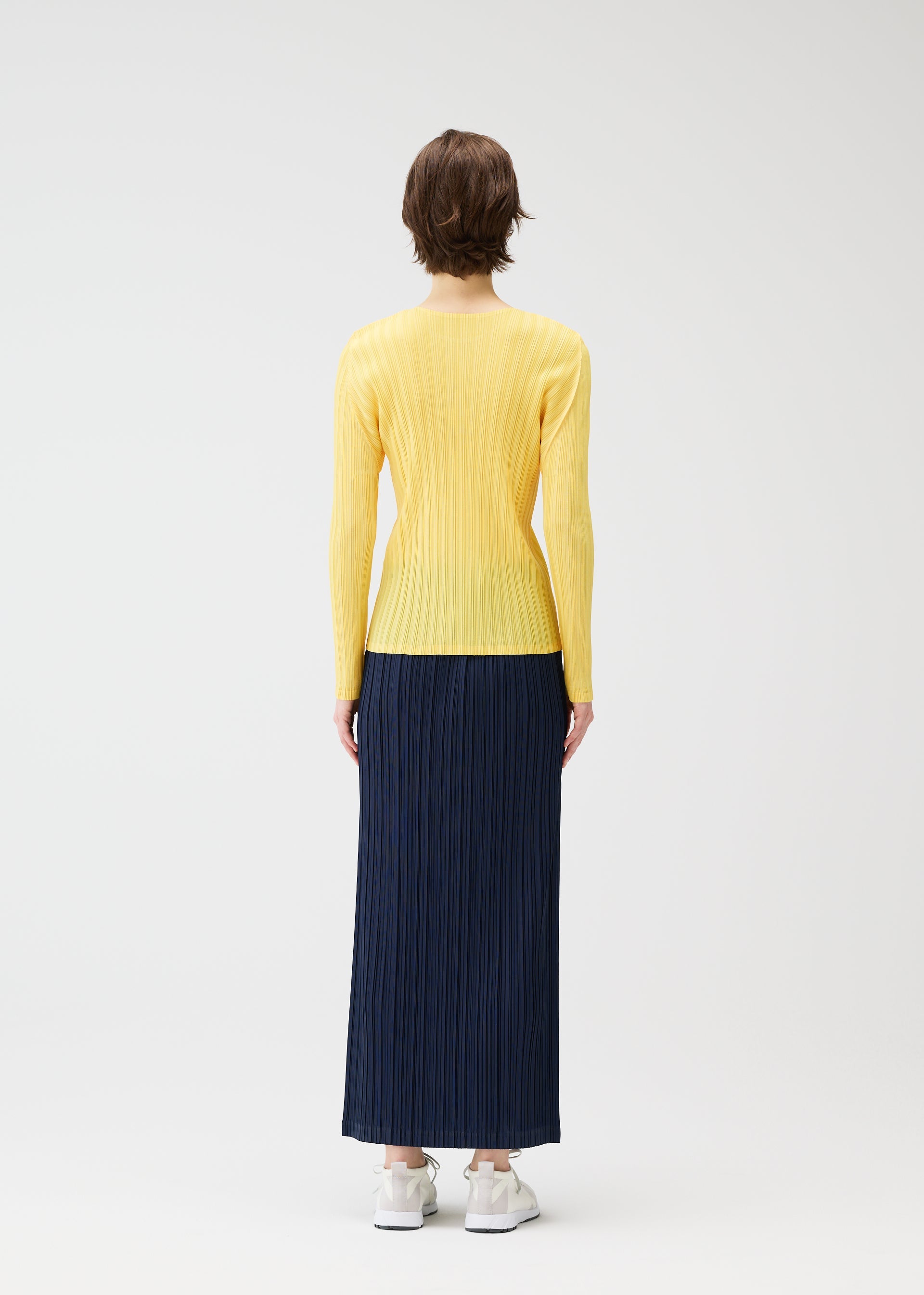 A model wears the PLEATS PLEASE ISSEY MIYAKE THICKER BOTTOMS 1 clothing.