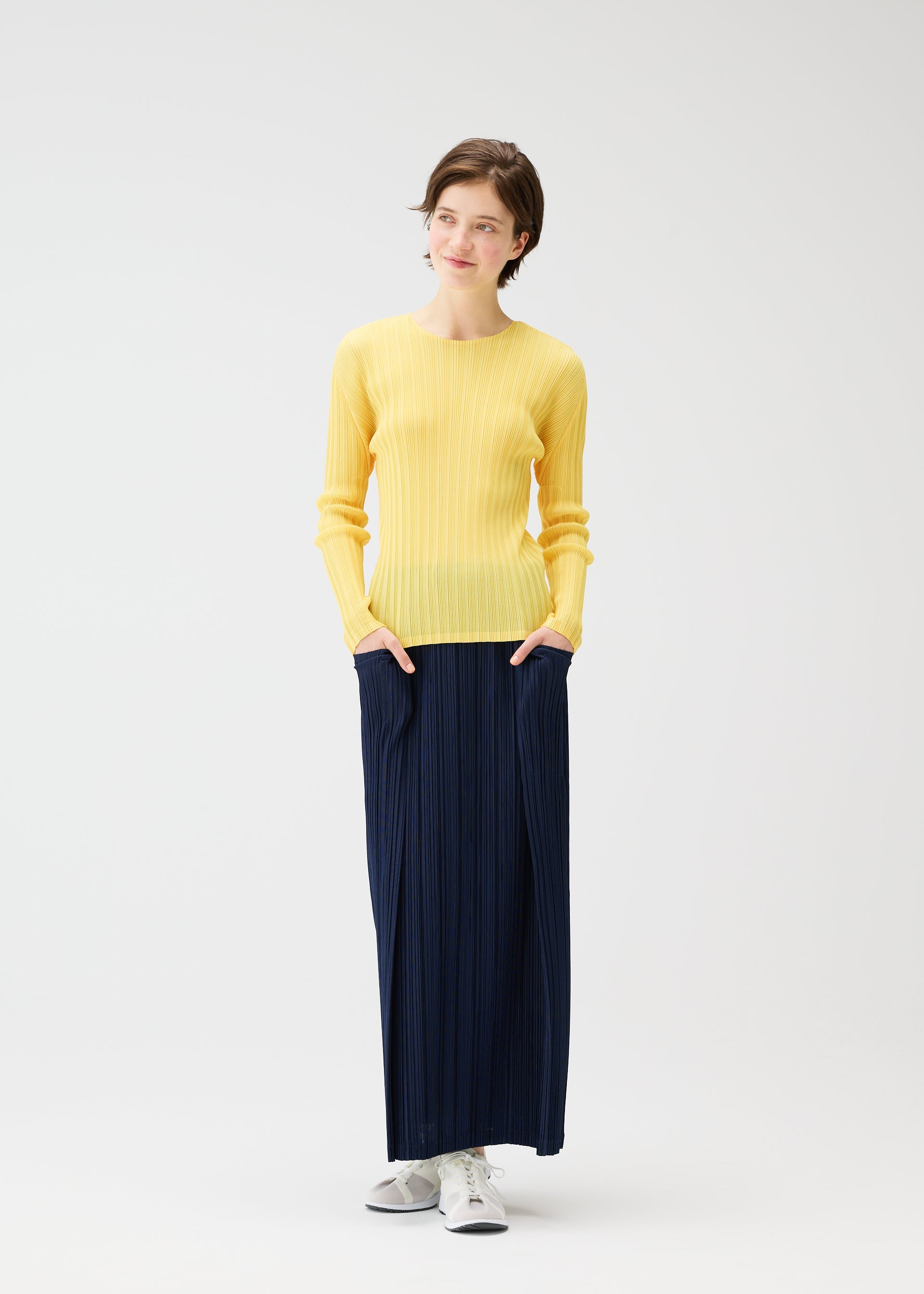 A model wears the PLEATS PLEASE ISSEY MIYAKE THICKER BOTTOMS 1 clothing.