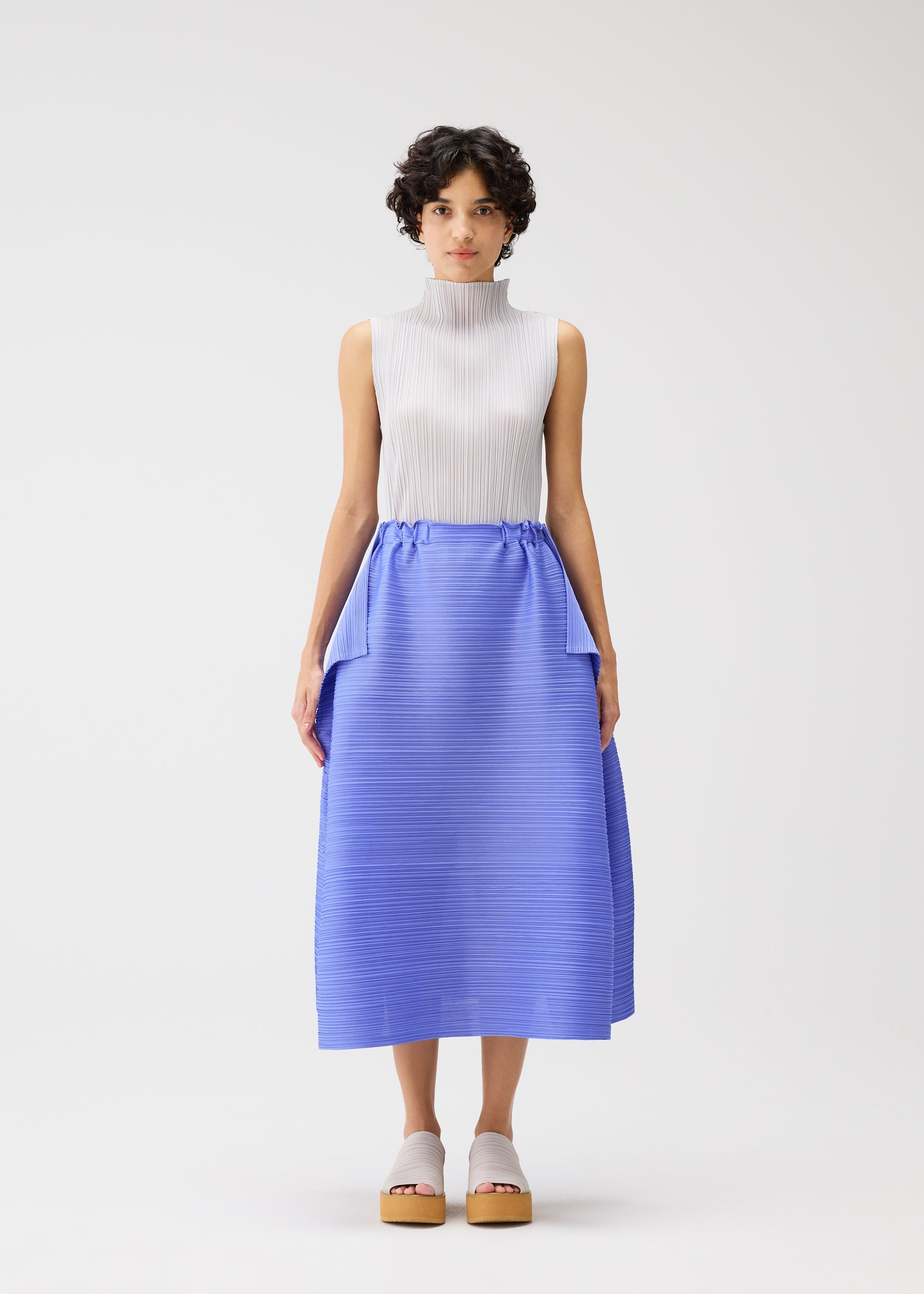 A model wears the PLEATS PLEASE ISSEY MIYAKE BOUNCY BASKET bouncy-basket-skirt-yellow-green.