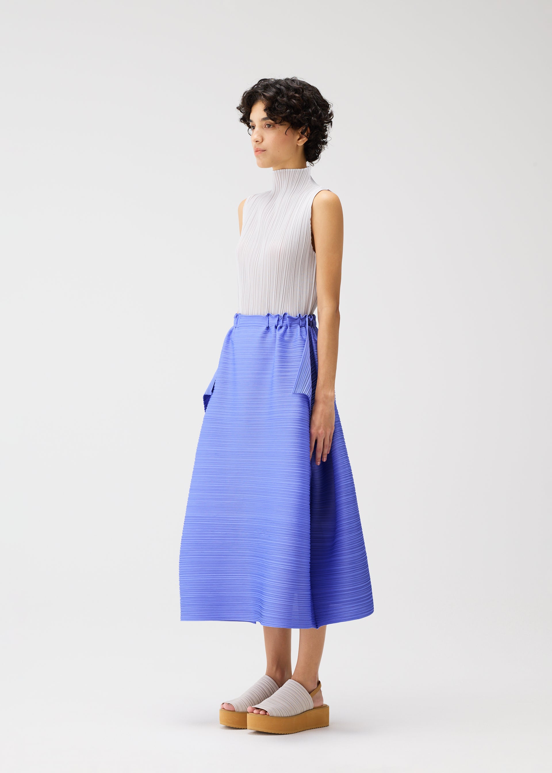 A model wears the PLEATS PLEASE ISSEY MIYAKE BOUNCY BASKET bouncy-basket-skirt-charcoal.
