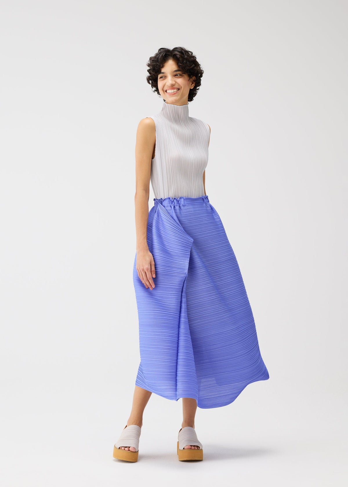 A model wears the PLEATS PLEASE ISSEY MIYAKE BOUNCY BASKET bouncy-basket-skirt-steel-blue.