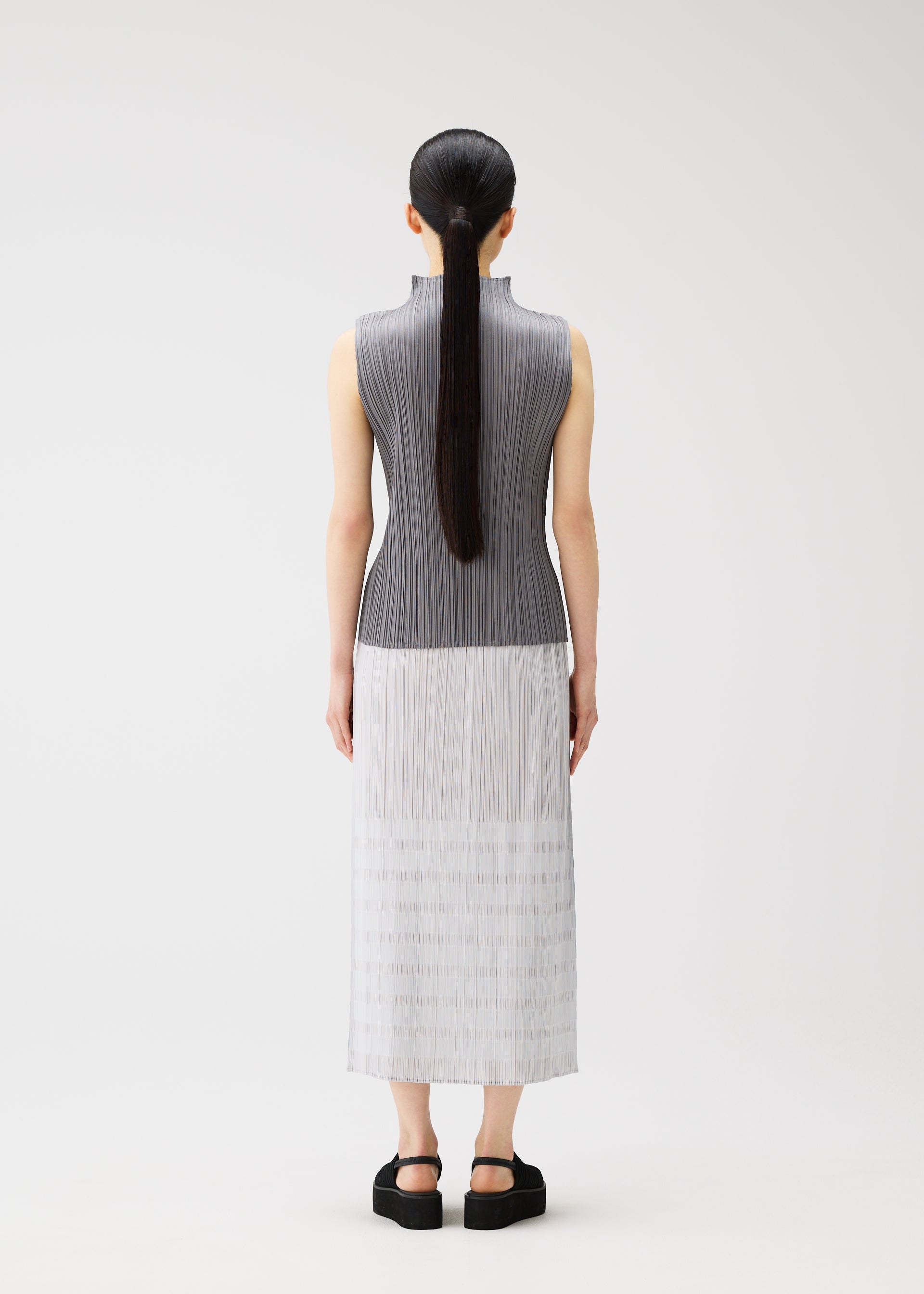 A model wears the PLEATS PLEASE ISSEY MIYAKE BUMPY BASKET bumpy-basket-skirt-pink.
