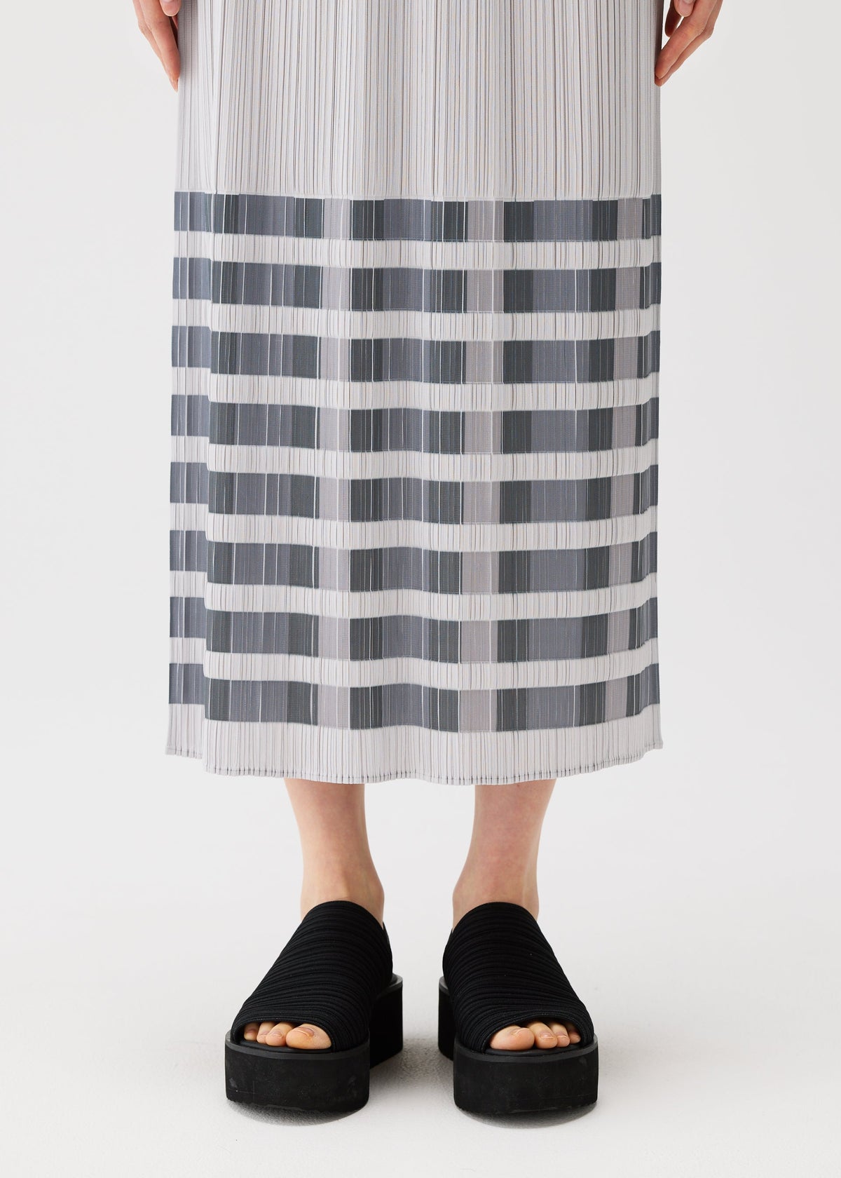 A model wears the PLEATS PLEASE ISSEY MIYAKE BUMPY BASKET bumpy-basket-skirt-green.