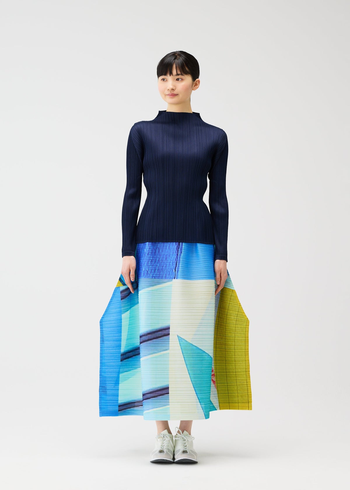 A model wears the PLEATS PLEASE ISSEY MIYAKE CITY COLLAGE clothing.