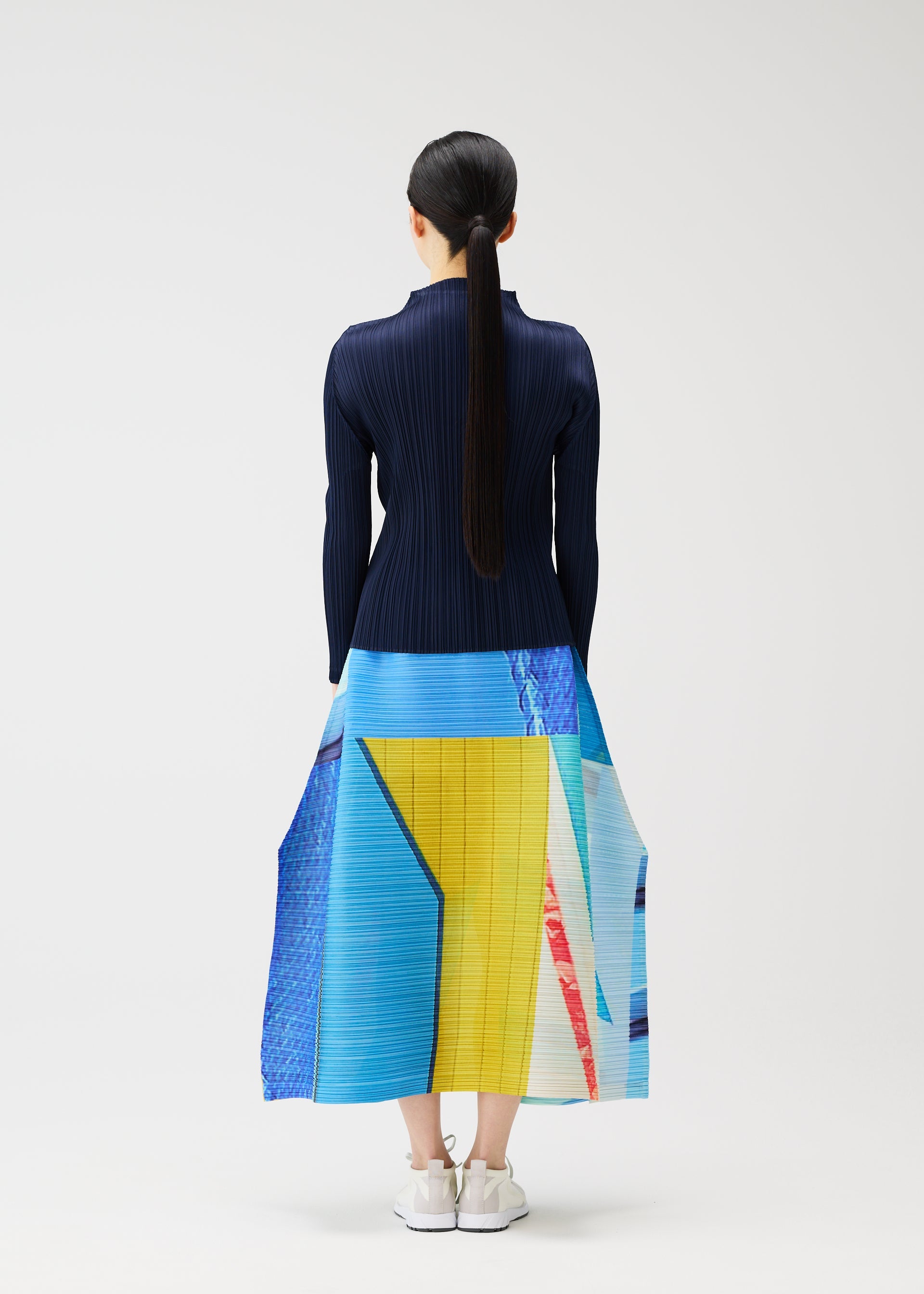 A model wears the PLEATS PLEASE ISSEY MIYAKE CITY COLLAGE clothing.